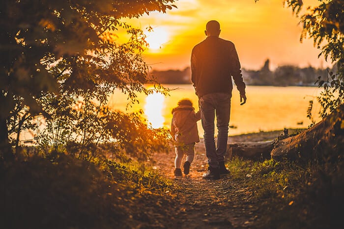 Father and daughter walking in the sunset